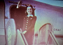Load image into Gallery viewer, Stewardess waves from the doorway of a Northwest DC-4 at Tokyo's Haneda Airport in early 1948.