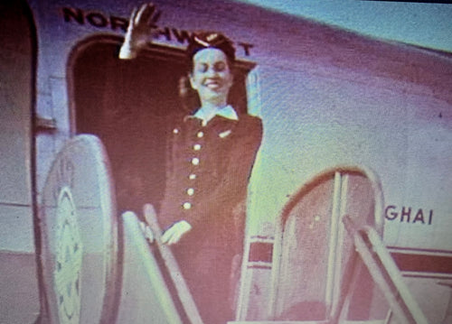 Stewardess waves from the doorway of a Northwest DC-4 at Tokyo's Haneda Airport in early 1948.